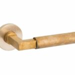 Deurkruk op geveerd rozet Bauhaus/Vivo messing antiek