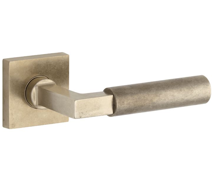 Deurkruk op geveerd rozet verdekt Bauhaus messing antiek