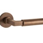 Deurkruk op geveerd rozet Bauhaus/Vivo messing antiek brons