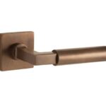 Deurkruk op geveerd rozet verdekt Bauhaus messing antiek brons