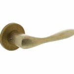 Deurkruk Banaan met rozet ø49x7mm verdekt messing getrommeld